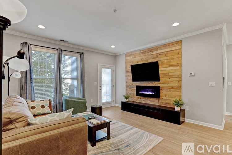 A living room with a brown couch and a wooden wall.