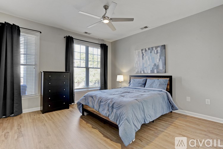 A bedroom with a bed, dresser, and window.