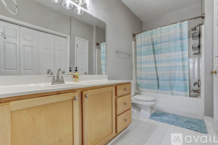 A bathroom with a white sink and wooden cabinets.