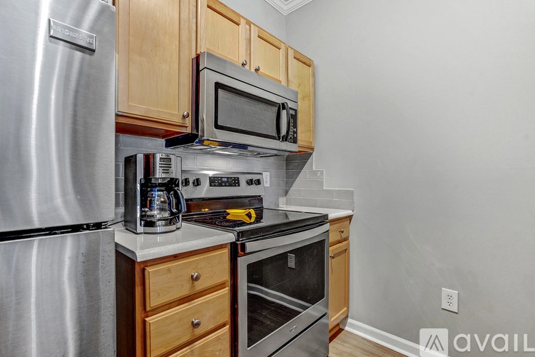 A kitchen with a stainless steel refrigerator, microwave, oven, and coffee maker.