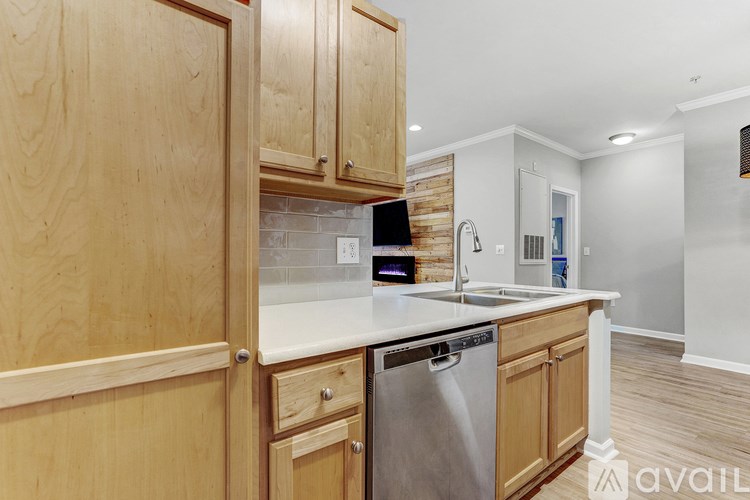A kitchen with wooden cabinets and a stainless steel dishwasher.