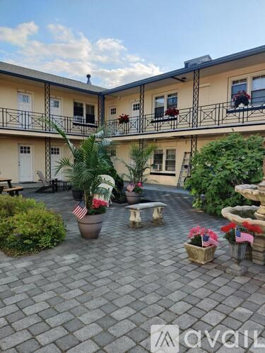 A courtyard with a fountain and potted plants.