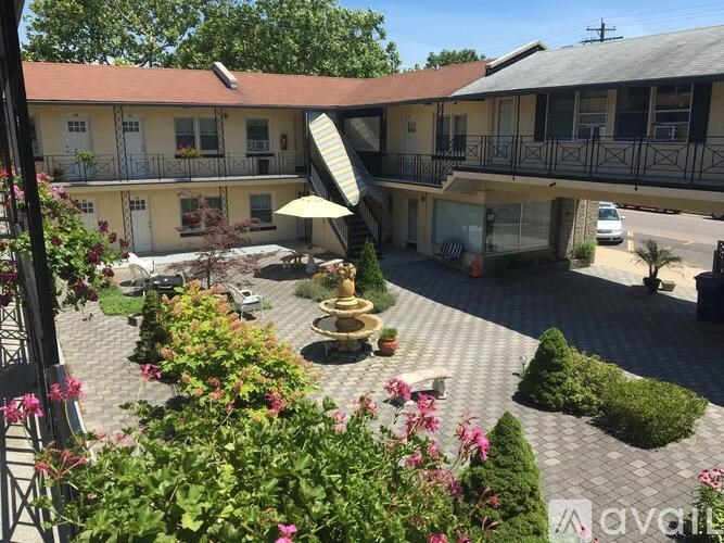 A courtyard with a fountain and a building in the background.