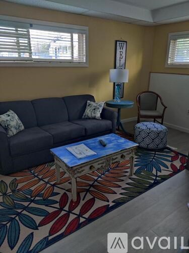 A living room with a grey sofa, a blue side table, and a wooden coffee table with a blue top.