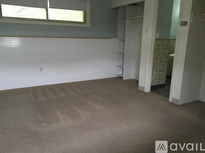 A room with a carpeted floor and a window.