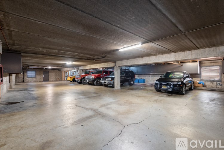 A black car is parked in a large, empty garage.
