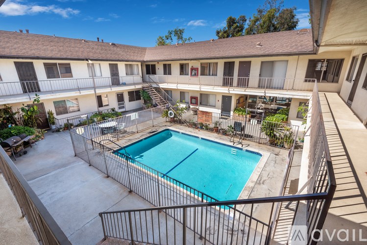 A pool surrounded by a black fence in a courtyard.