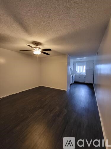 A room with a ceiling fan and wooden flooring.