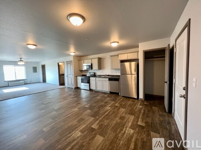 A spacious kitchen with stainless steel appliances and wooden flooring.