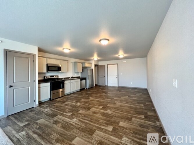 A spacious living area with a kitchen in the background.