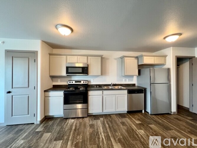 A kitchen with white cabinets and a wooden floor.