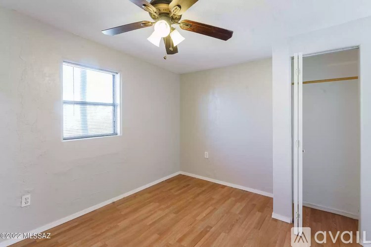A room with a ceiling fan and a window.