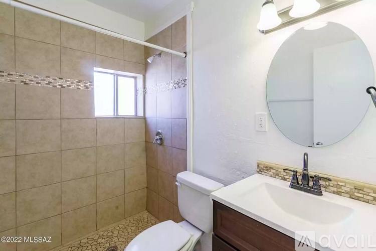 A bathroom with a toilet, sink, and shower.