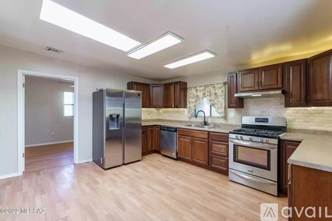 A kitchen with wooden cabinets and a stainless steel refrigerator.