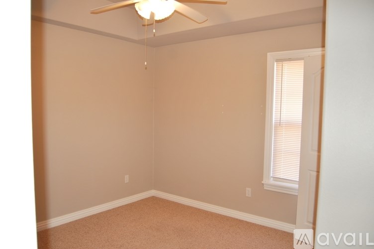 A room with a ceiling fan and a window with blinds.