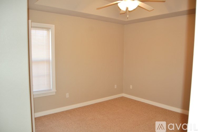A room with a ceiling fan and a window with blinds.