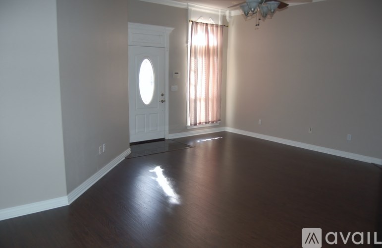 A room with a white door and a window with curtains.