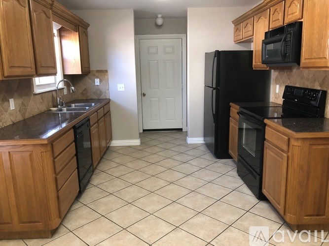 A kitchen with black appliances and wooden cabinets.