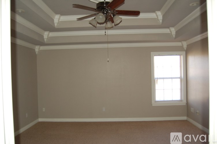 A room with a ceiling fan and a window.