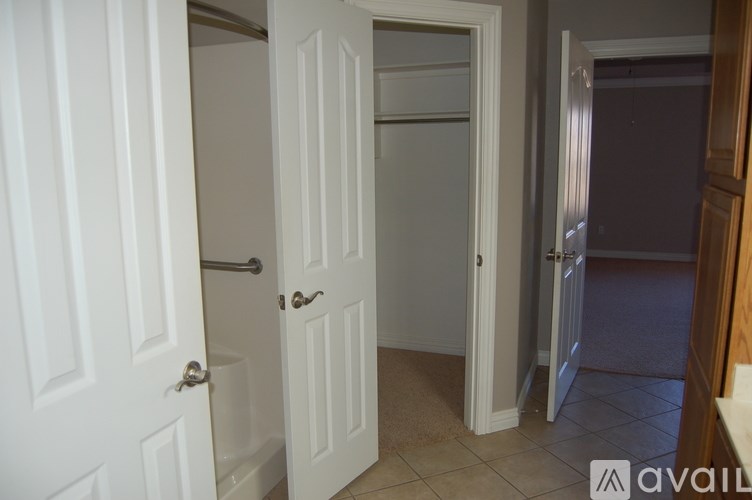 A hallway with two doors and a tiled floor.