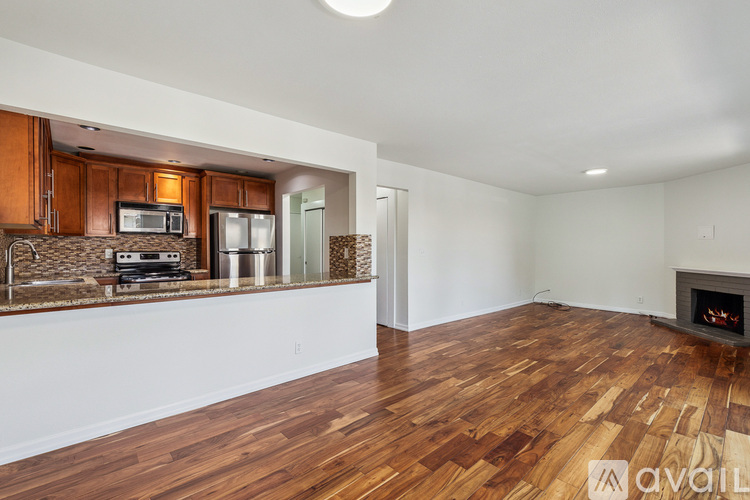 A room with wooden floors and a fireplace is available for rent.