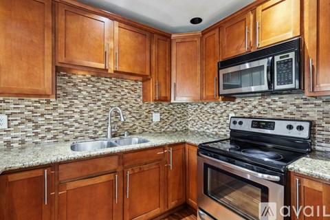 A kitchen with wooden cabinets and a black stove top oven.