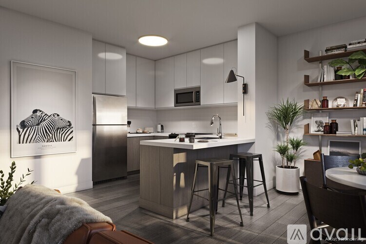 A modern kitchen with a bar stool and a fridge.