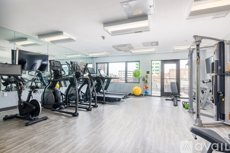 A well-lit gym with a variety of exercise equipment.