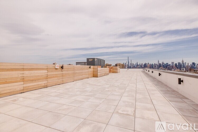 A rooftop with wooden panels and a city skyline in the distance.
