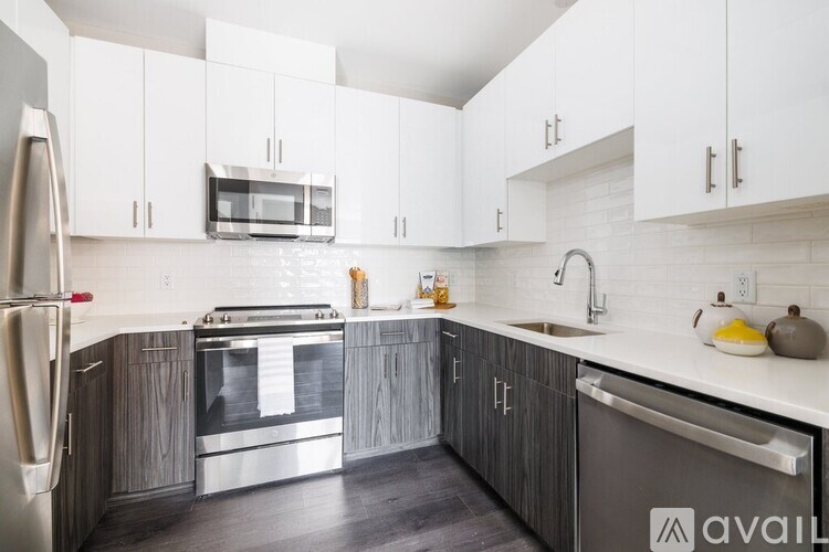 A kitchen with white cabinets and a stainless steel refrigerator.