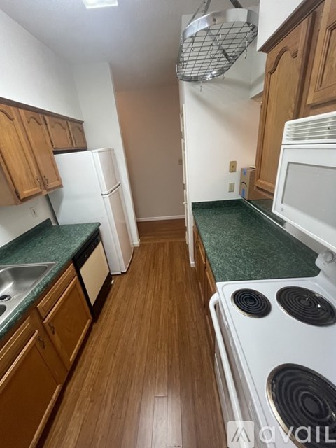 A kitchen with wooden cabinets and a white fridge.
