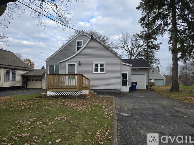 A house with a grey roof and a white garage door is available for rent.