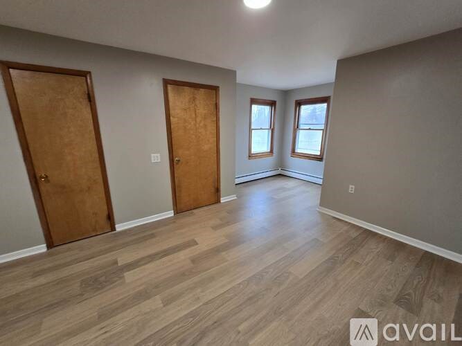 A room with wooden floors and two doors.