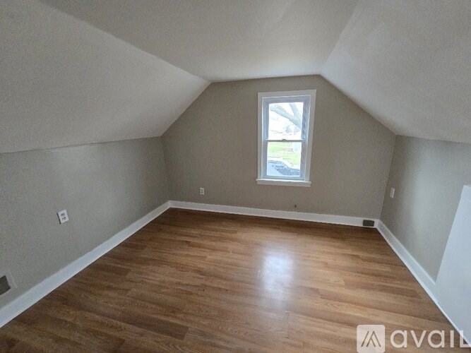 A room with wooden flooring and a window.