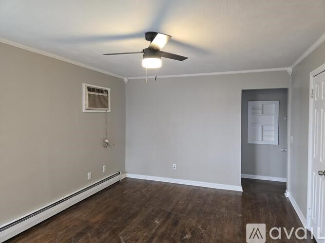 A room with a ceiling fan and wooden floors.
