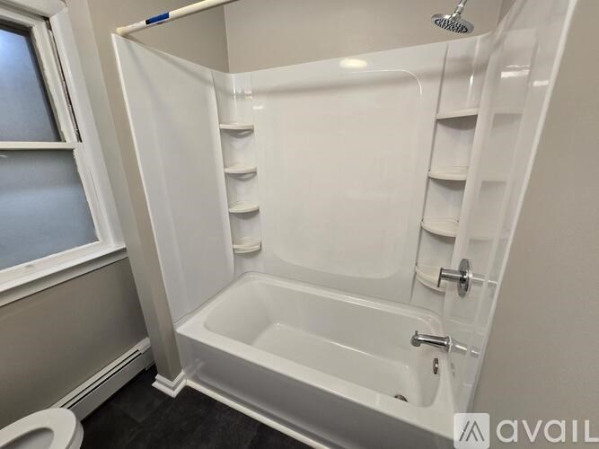 A white bathroom with a tub and toilet.