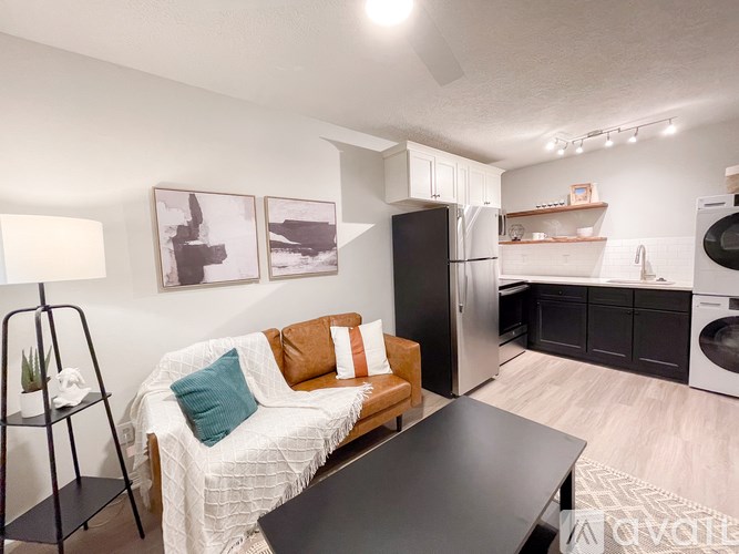 A modern kitchen with a black refrigerator and a black washing machine.
