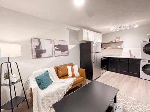 A modern kitchen with a black refrigerator and a black washing machine.