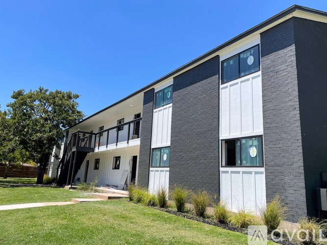 A modern building with a grassy area in front.
