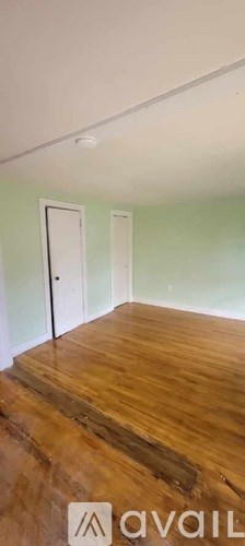 A room with wooden floors and two doors.