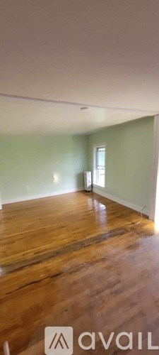 A room with wooden flooring and a window.