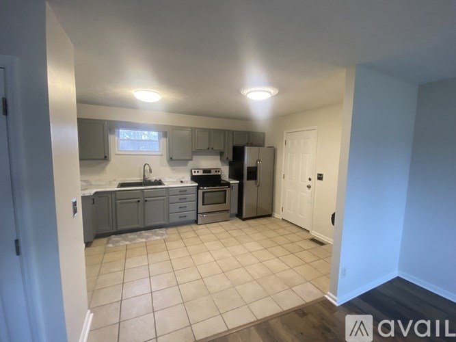 A kitchen with white cabinets and a tiled floor.