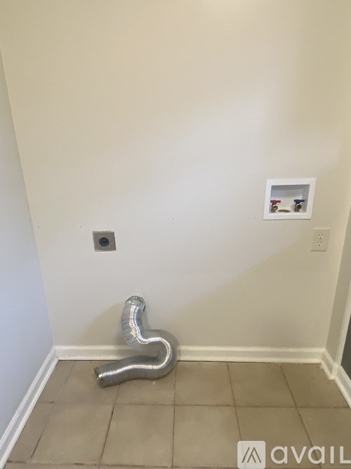 A silver flexible duct is on the floor.
