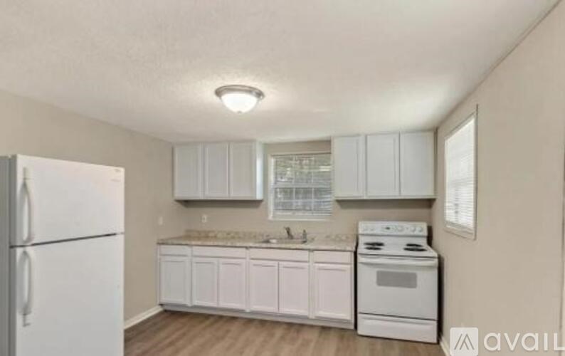 A kitchen with white appliances and cabinets.
