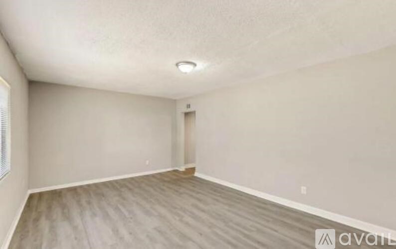 A room with wooden flooring and a white ceiling.