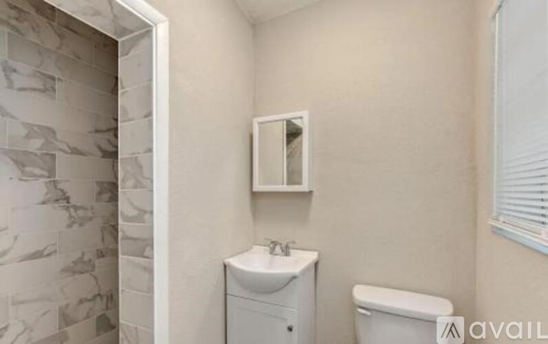 A bathroom with a sink, toilet and a mirror.