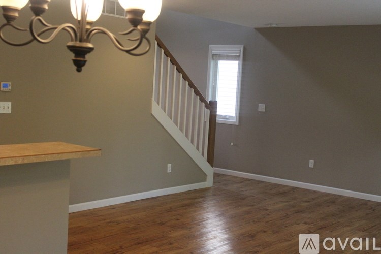 A room with a wooden floor and a staircase.