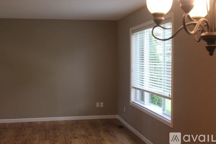 A room with a window and a chandelier.
