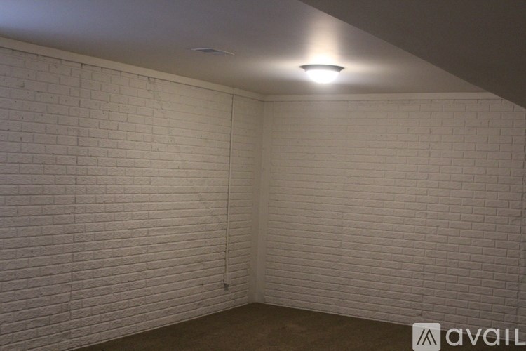 A room with white brick walls and a light on the ceiling.