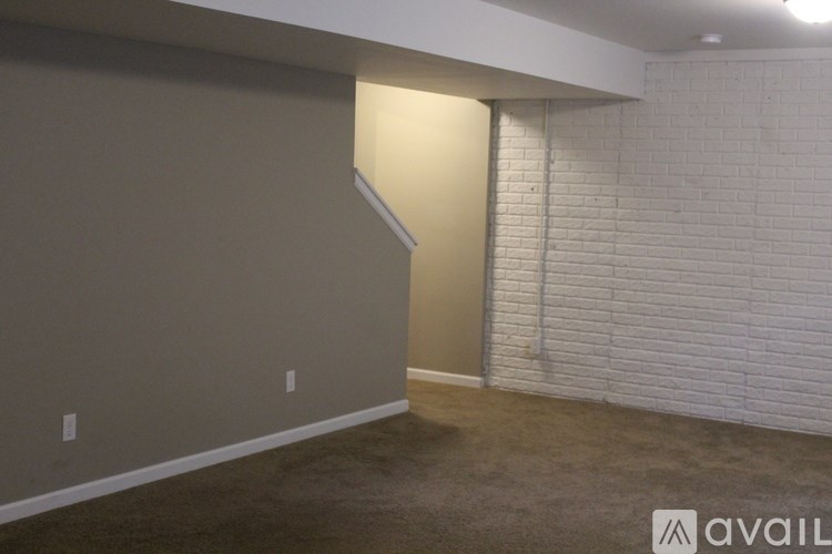 A room with a white brick wall and a carpeted floor.